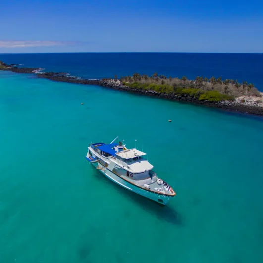 The Beluga yacht anchored in a turquoise Galápagos bay