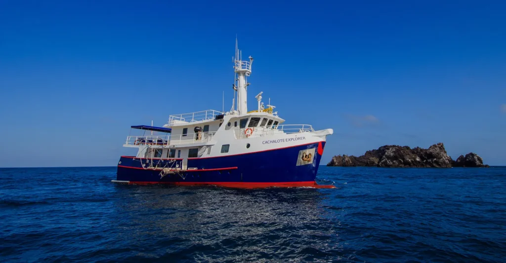 The Cachalote Explorer yacht off a rocky Galápagos islet