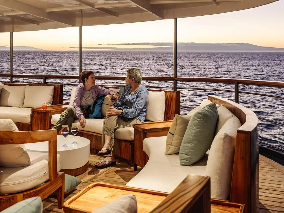 Guests in the al-fresco lounge of the Evolution yacht at sunset
