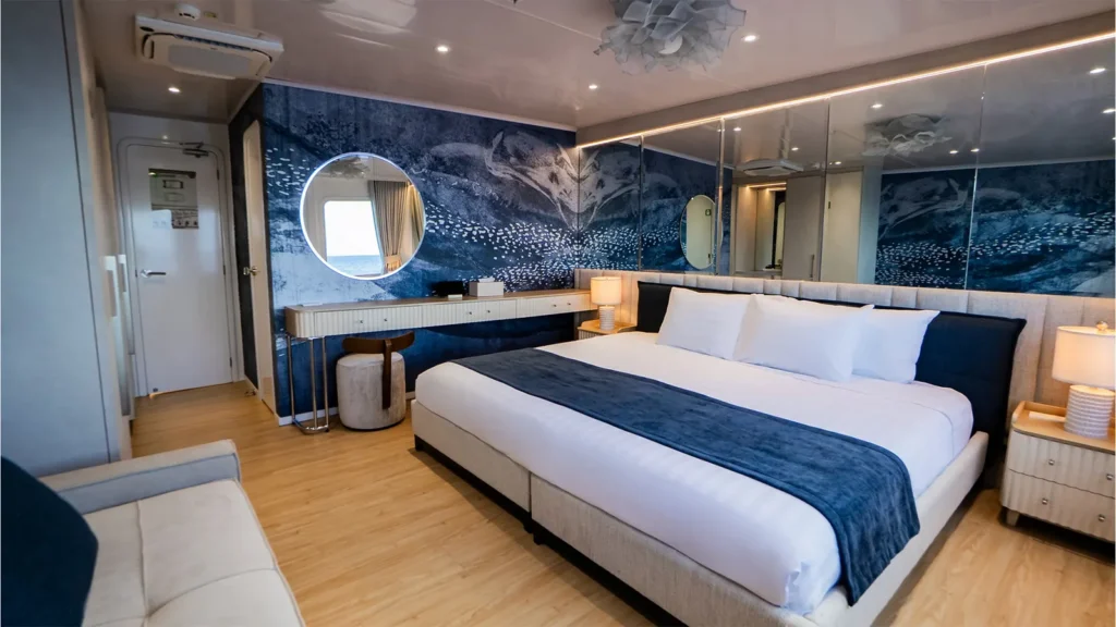 Golden stateroom with a king bed on the Monique