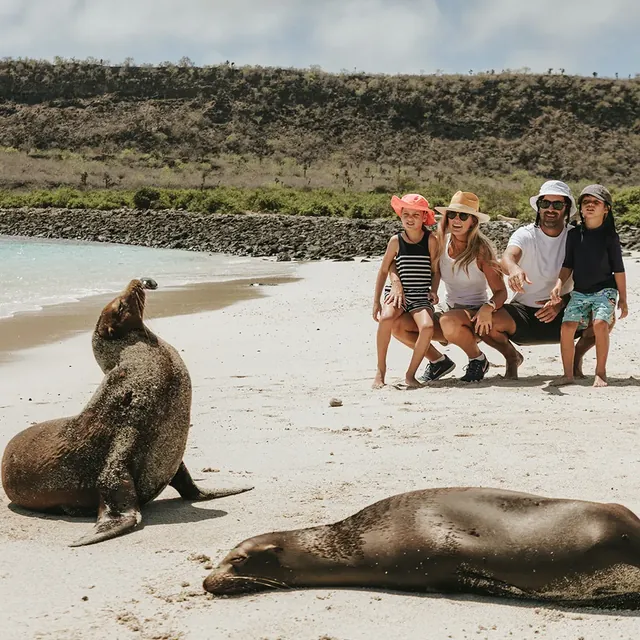 A family on a Galápagos beach with sea lions (photo: Pikaia Lodge)